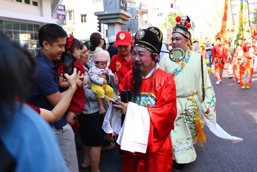 Dong nguoi dan dung doc hai ben duong de chao mung, cam theo nhang, chap tay cau nguyen khi doan ruoc tuong Quan Cong di ngang qua de lay via may man, tai loc dau nam.