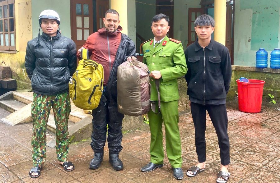 Foreign tourists (second from the left) receive the bag back. Photo: Police of Huc Nghi commune