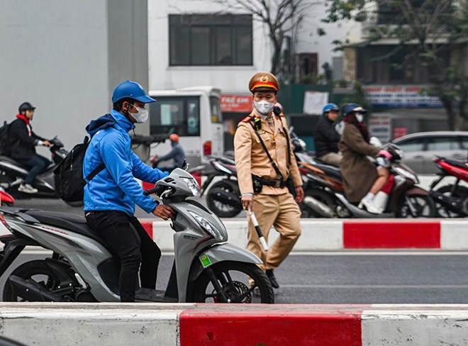Traffic police check the motorbike driver. Photo: N. Tuan
