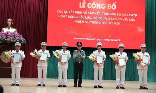 Giám đốc Công an TPHCM Lê Hồng Nam trao quyết định cho 6 cán bộ nghỉ chờ hưu. Ảnh: Sỹ Đông