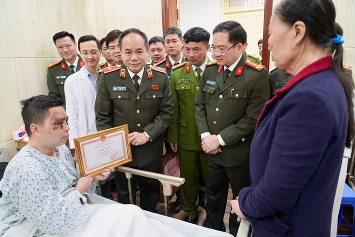 Major General Nguyen Thanh Tung - Director of Hanoi City Police presented a Certificate of Merit to Major Nguyen Ngoc Anh. Photo: Ngan Nguyen