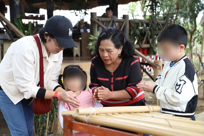Meritorious Artist Y Sinh shares the story of the origin and meaning of K'long Put, attracting the attention of tourists. Photo: Hai Dang