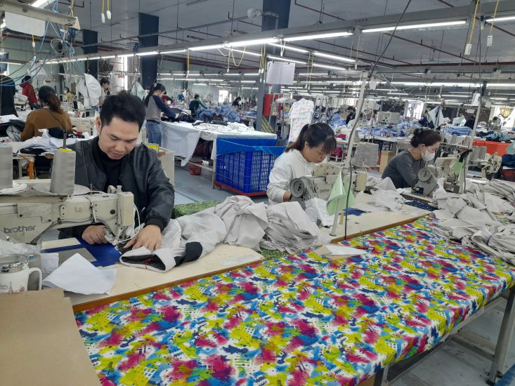 Mr. Tran Duy Do (in black jacket) is sewing products. Photo: Tran Duy