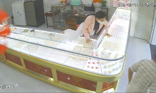Bà chủ trèo qua tủ, lao ra cản tên cướp tiệm vàng tháo chạy. Ảnh cắt clip