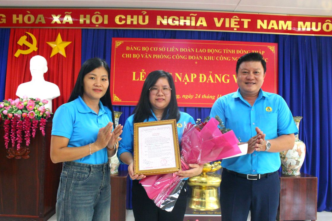 Trương Thị Thùy Linh (trái ảnh) tặng hoa chúc mừng công nhân Khu công nghiệp Sa Đéc được kết nạp Đảng. Ảnh: Thanh Mai 