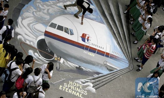 Học sinh Philippines xem tranh graffiti ba chiều về chuyến bay MH370 mất tích, ngày 17.3.2014. Ảnh: Xinhua