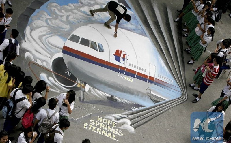 Philippine students watch three-dimensional graffiti paintings about the missing flight MH370, March 17, 2014. Photo: Xinhua