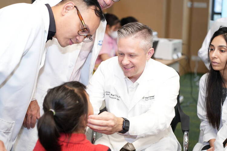 Dr. Runyan examines a disabled child before surgery. Photo: Provided by Nuoy