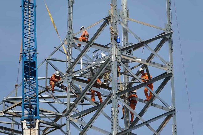 Workers installing 500kV power poles, circuit 3 in Ha Tinh. Photo: Tran Tuan