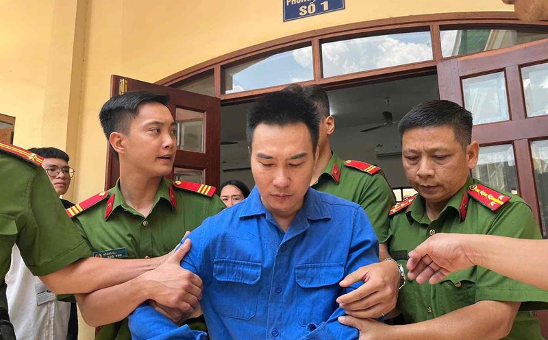 Taking defendant Danh Son (former doctor who killed his lover) onto a bus after the People's Court of Dong Nai province sentenced him to death. Photo: HAC