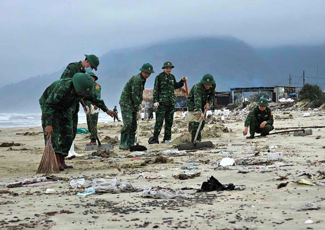 The authorities collected the scattered oil drifting ashore. Photo: Phuc Dat.