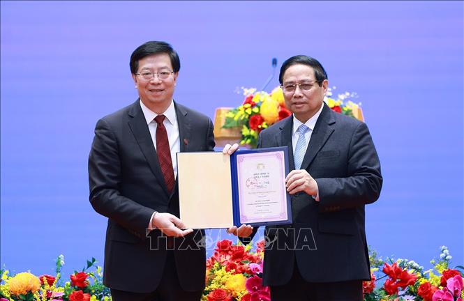 Politburo member and Prime Minister Pham Minh Chinh received the title of " Honored Professor of Hanoi University" awarded by Thanh Hoa University Party Secretary Khoi Dung. Photo: VNA