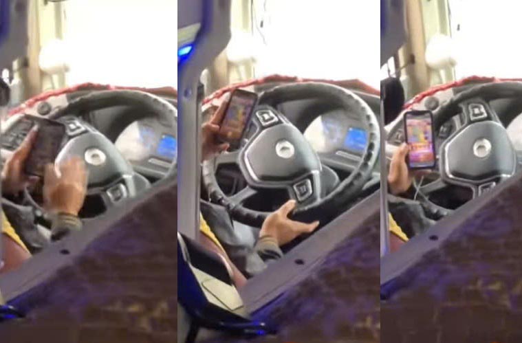 Image cut from a clip of a bus driver in Ha Tinh driving while playing a game.