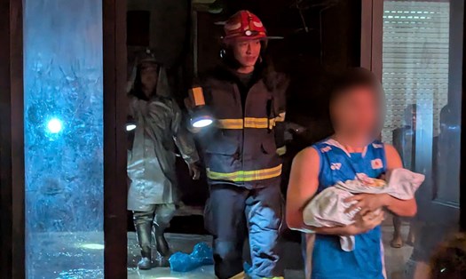 Lực lượng chức năng hướng dẫn người trong nhà thoát nạn an toàn. Ảnh: Công an Hà Nội