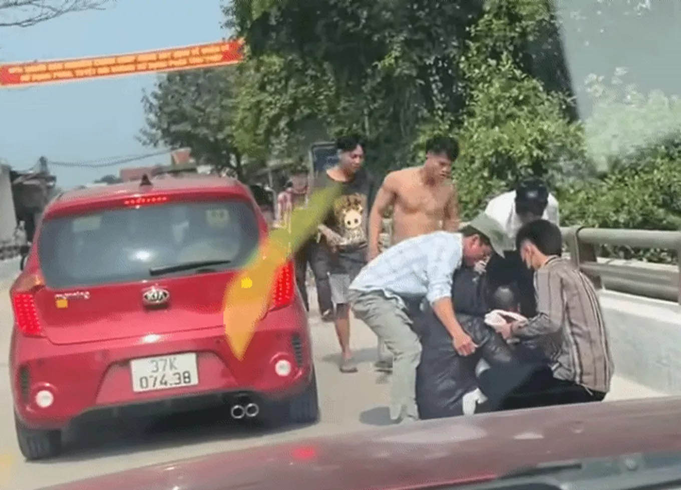 Nhiều người can ngăn người phụ nữ ôm 2 con nhỏ có ý định nhảy cầu. Ảnh cắt từ clip.