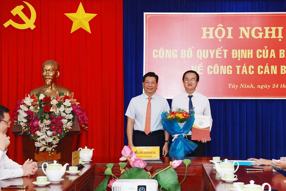 Tay Ninh Provincial Party Secretary Nguyen Manh Hung presented the decision and presented flowers to congratulate Mr. Phan Huynh Quoc Vinh (right). Photo: To Tuan/Tay Ninh Newspaper