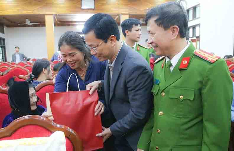 Chu tich UBND Thanh pho Ha Tinh Nguyen Trong Hieu tang qua cho me liet si den lay mau ADN. Anh: Cong an Ha Tinh.