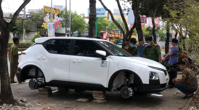 Cơ quan chức năng kiểm tra hiện trường chiếc xe bị trộm mất 4 bánh. Ảnh: Nhật Hồ