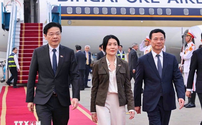 Minister of Science and Technology Nguyen Manh Hung (right) welcomed Singaporean Prime Minister Lawrence Wong and his wife at Noi Bai International Airport. Photo: VNA
