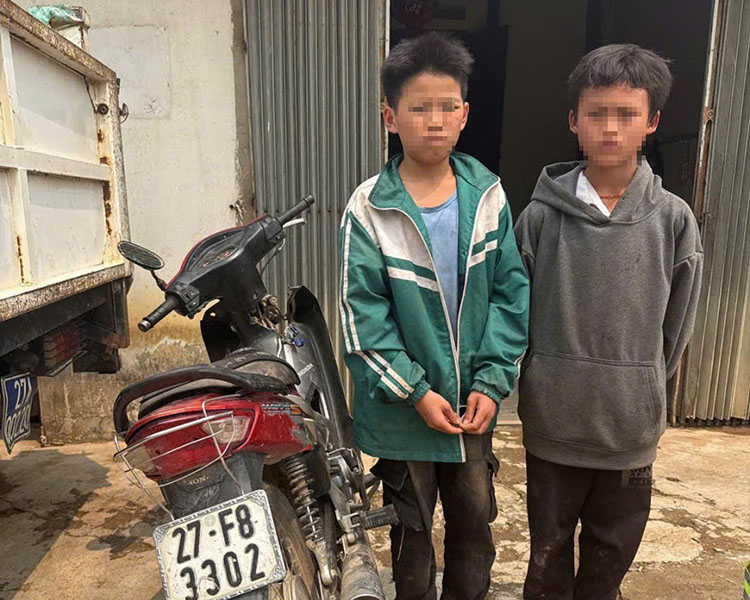Lo Duc Khang (standing next to a motorbike) and Sung A Si with a stolen motorbike in Hoa Ngam commune, Dien Bien district. Photo: Provided by the police