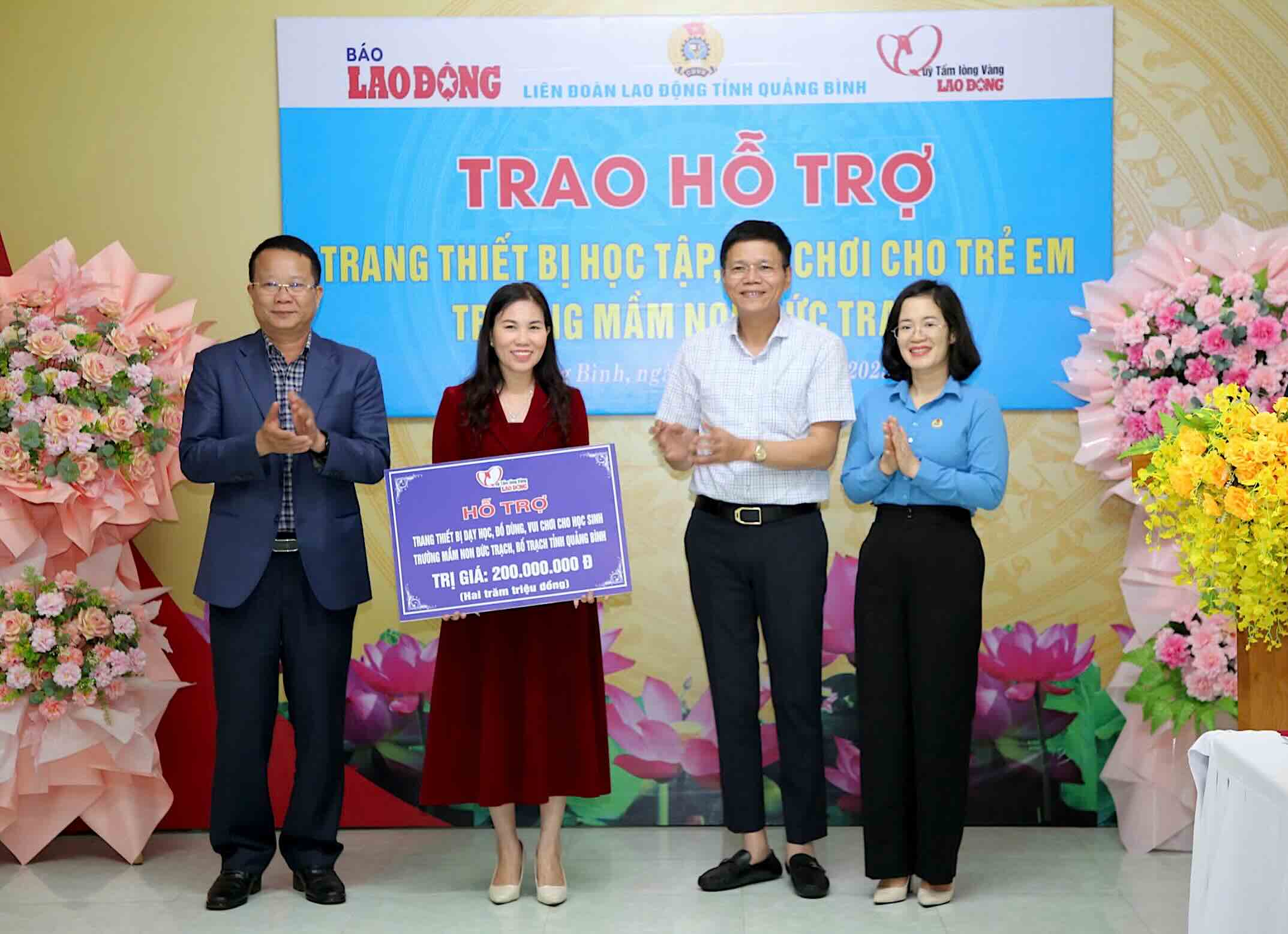 Mr. Nguyen Ngoc Hien - Editor-in-Chief of Lao Dong Newspaper, Director of the Golden Heart Social Charity Fund (second from right) presented a symbol to support learning and playing equipment to Duc Trach Kindergarten. Photo: Cong Sang.
