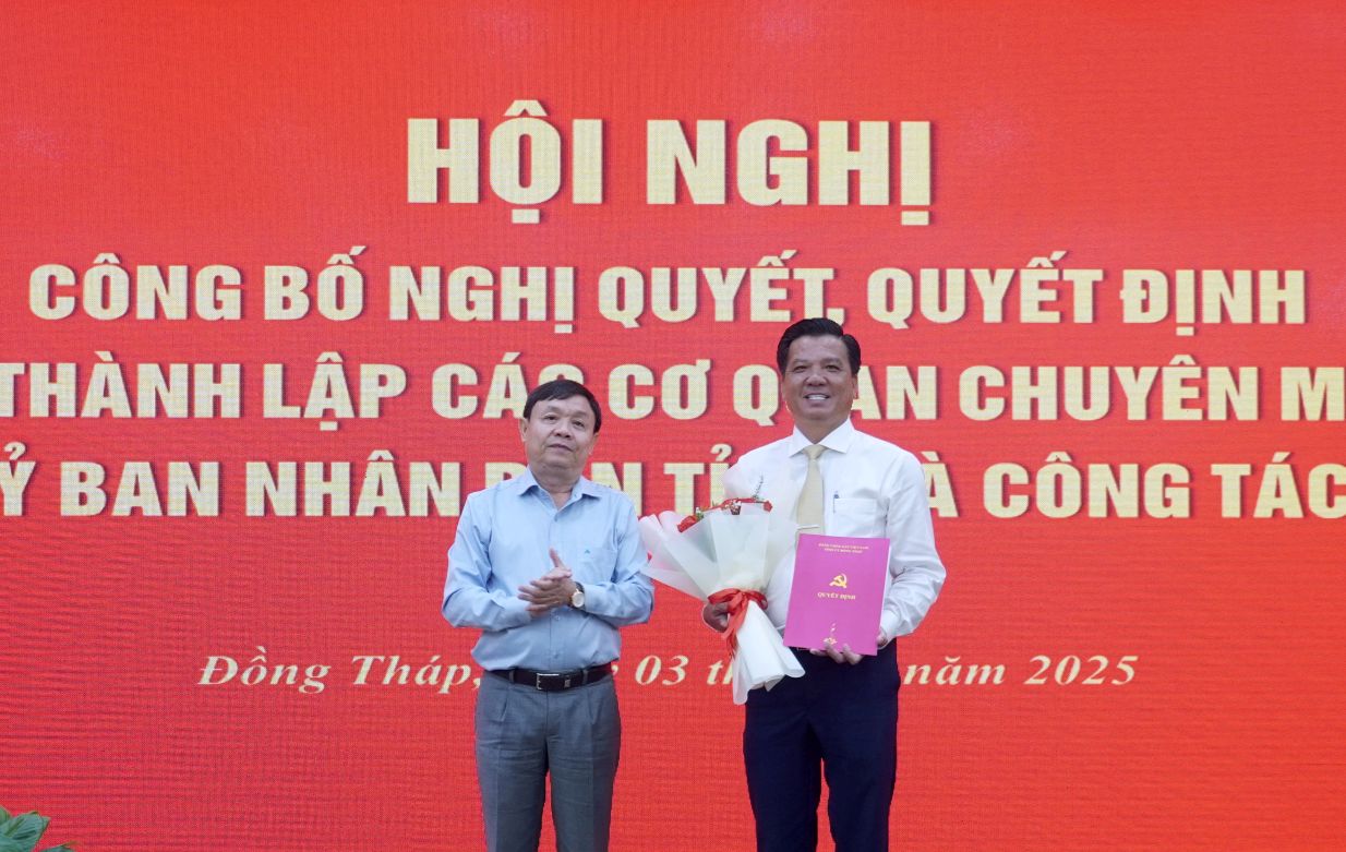 Ong Phan Van Thang - Pho Bi thu Thuong truc Tinh uy, Chu tich HDND  tinh, Bi thu Dang uy cac co quan Dang tinh (ben trai) trao Quyet dinh va tang hoa chuc mung dong chi Le Chi Thien. Anh: Kim Sa