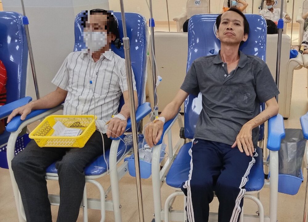 El autor (derecha) mientras administra un medicamento para el cancer. Imagen de Nguyen Thi Tuoi