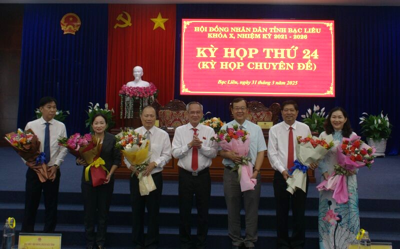 The Secretary of the Bac Lieu Provincial Party Committee presented flowers to the members of the Provincial People's Committee and delegates of the Provincial People's Council who requested dismissal. Photo: Nhat Ho