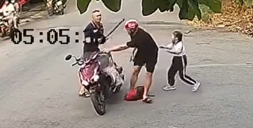 Hình ảnh tài xế ôtô cầm gậy bóng chày đánh đập người cha chở con đi học. Ảnh: cắt từ clip