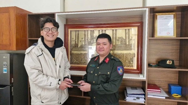 Cán bộ Phòng Cảnh sát Cơ động trao trả tài sản cho anh Nguyễn Phạm Huy Hoàng. Ảnh: CAHN