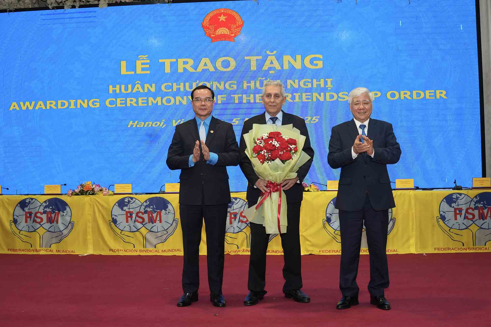Chairman of the Central Committee of the Vietnam Fatherland Front Do Van Chien (far right) and President of the Vietnam General Confederation of Labor, Vice President of the World Trade Union Federation Nguyen Dinh Khang (far left) congratulate comrade Georgios Mavrikos. Photo: Huu Chanh
