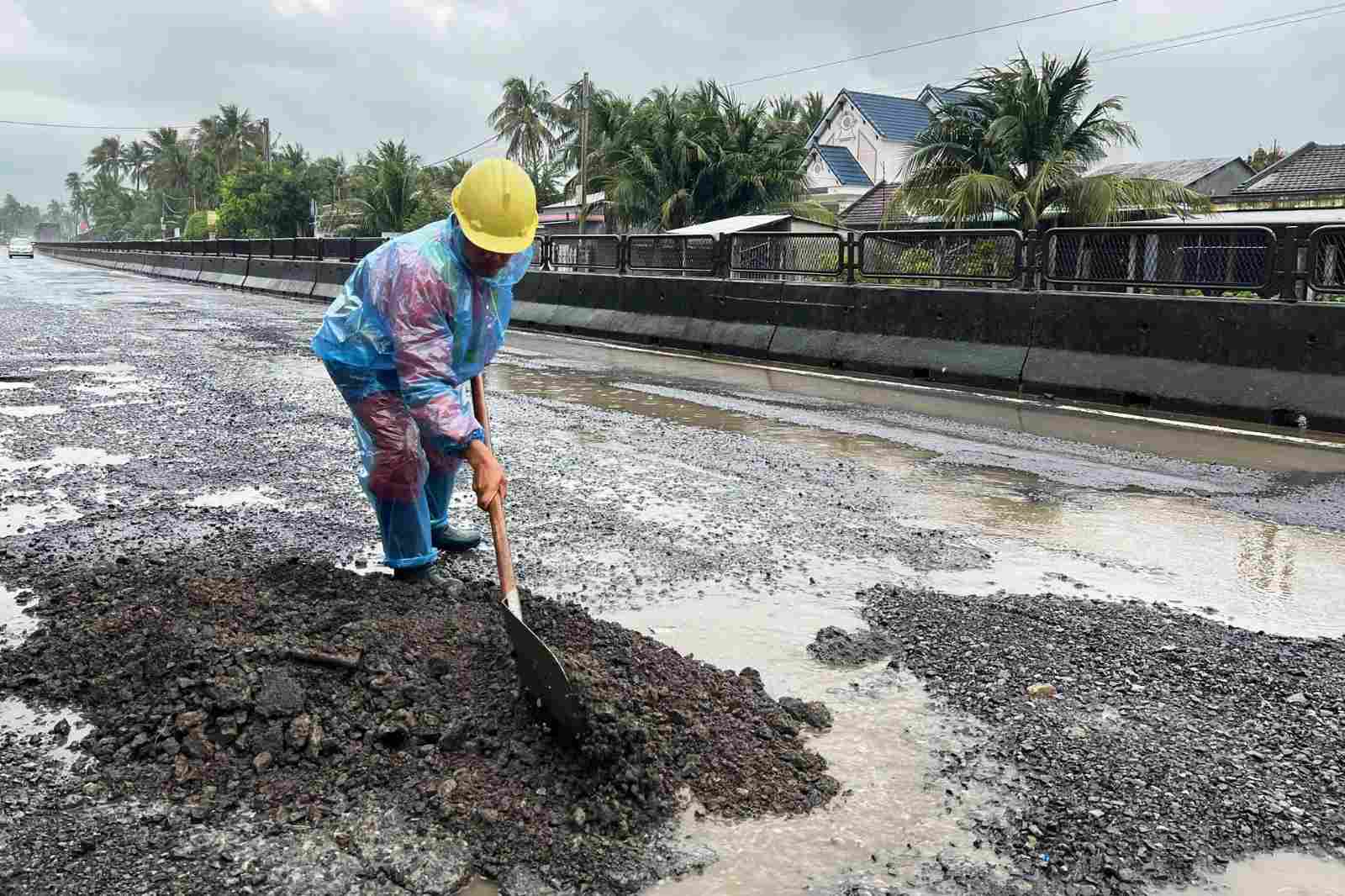 Workers of Phu Yen Road Management and Repair Joint Stock Company temporarily patch the damage on National Highway 1. Photo: Hoai Luan
