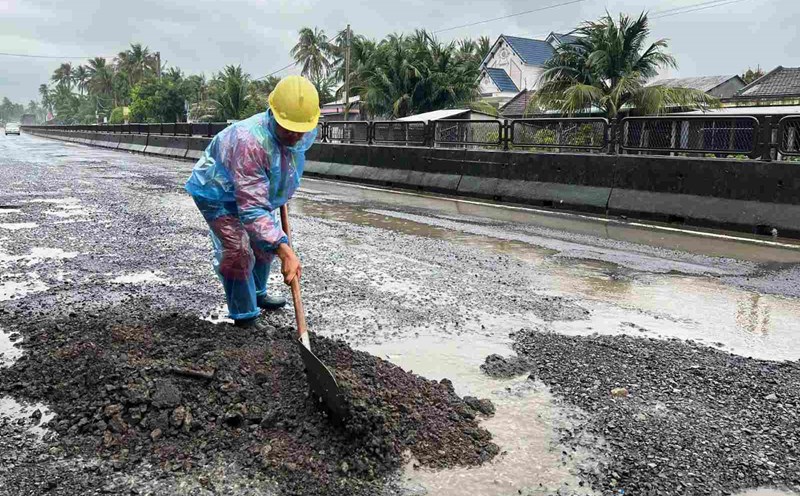 Workers of Phu Yen Road Management and Repair Joint Stock Company temporarily patch the damage on National Highway 1. Photo: Hoai Luan