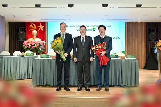 Mr. Nguyen Thanh Tung - Chairman of the Board of Directors of Vietcombank (standing in the middle) presented flowers to congratulate Mr. Le Quang Vinh - Deputy General Director in charge of the Executive Board (left) and presented flowers to express gratitude to Mr. Nguyen My Hao - former member of the Board of Directors of Vietcombank for the 2023 - 2028 term (right). Photo: Vietcombank