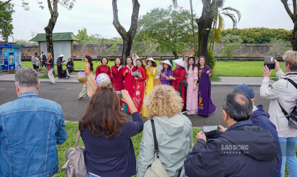  Thay vi chi dung yen va quan sat, nhieu du khach con chu dong tro thanh nhung “tho may anh” thuc thu, huong dan va tao dang cho cac chi em mac ao dai, tham chi la giup ho dieu chinh trang phuc sao cho dep nhat trong buc hinh. 