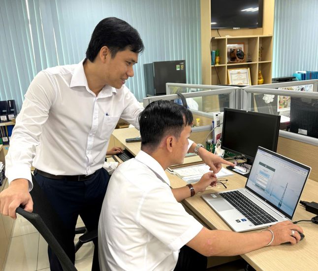 Mr. Nguyen Hoai Thuong (standing) discussed his professional skills with his colleagues. Photo: Duc Long