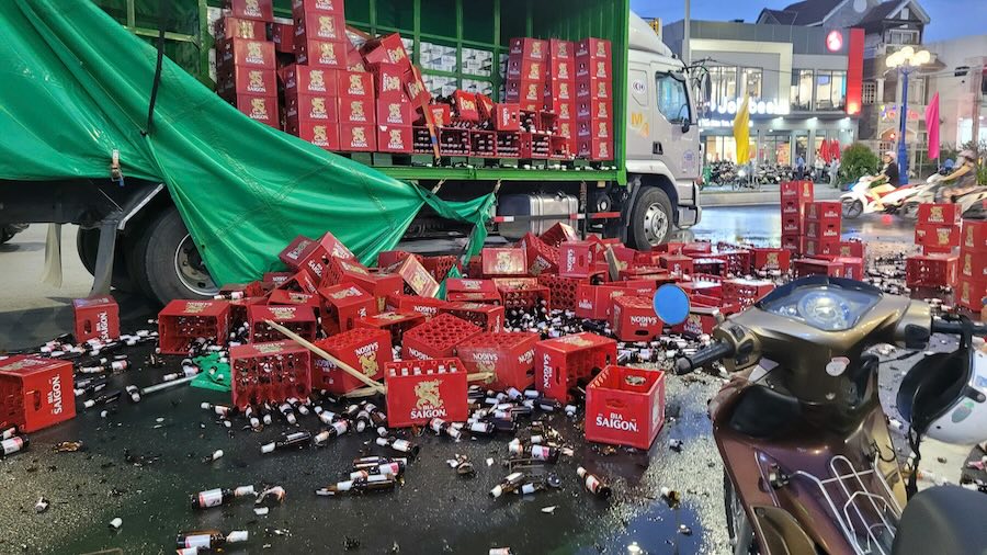 The scene of the truck carrying beer suddenly braking, hundreds of beer bins fell onto National Highway 62, obstructing traffic. Photo: Duy Minh
