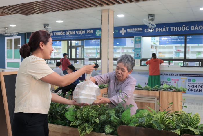 Ba P.T.H nhan phan com cho con va ban cung giuong benh. Anh: Song Han
