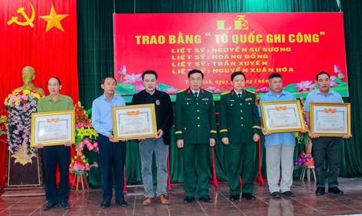 Thân nhân 4 liệt sĩ nhận Bằng Tổ quốc ghi công. Ảnh: Xuân Diện