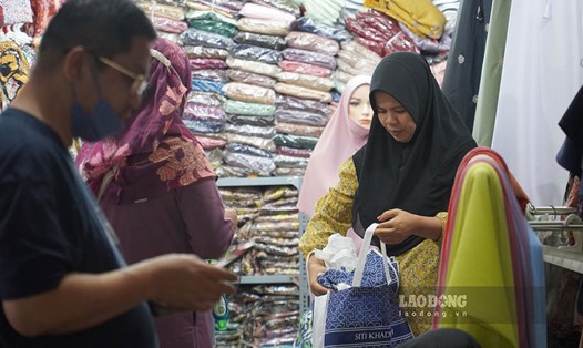 Du khách đang lựa chọn khăn choàng đầu truyền thống Hồi giáo tại khu phố Malaysia giữa TPHCM. Ảnh: Hạ Mây