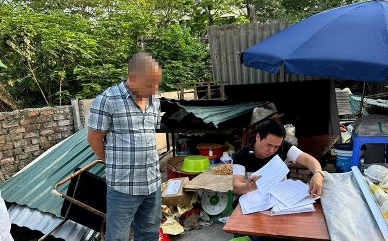Officers of Nam Tu Liem district transferred the enforcement notice to households in the area to recover land. Photo: Thanh Long