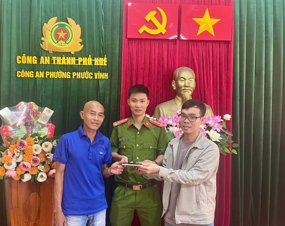 El Sr. Nguyen Thanh Khiem (izquierda) le devuelve el telefono al Sr. Nguyen Quoc Thinh (derecha) que se habia caido en la Policia de Phuoc Vinh, Hue. Foto: suministrada por la policia
