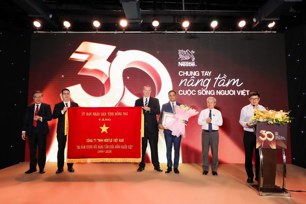 Dai dien tinh Dong Nai trao tang buc truong “30 Nam chung suc nang tam cuoc song nguoi Viet” cho Nestle Viet Nam. Anh: Ne