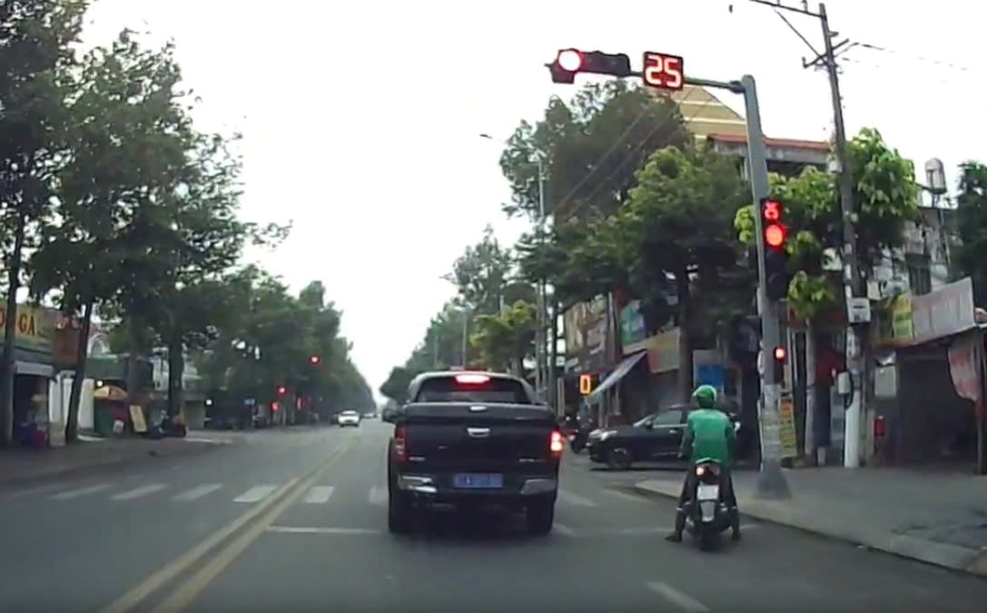 Imagen de un coche azul marino pasando una luz roja. El corto de un clip