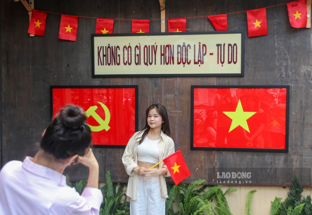 Niñas de Hue toman fotografias con la bandera nacional antes del 50 aniversario de la unidad nacional. Imagen de Nguyen Luan