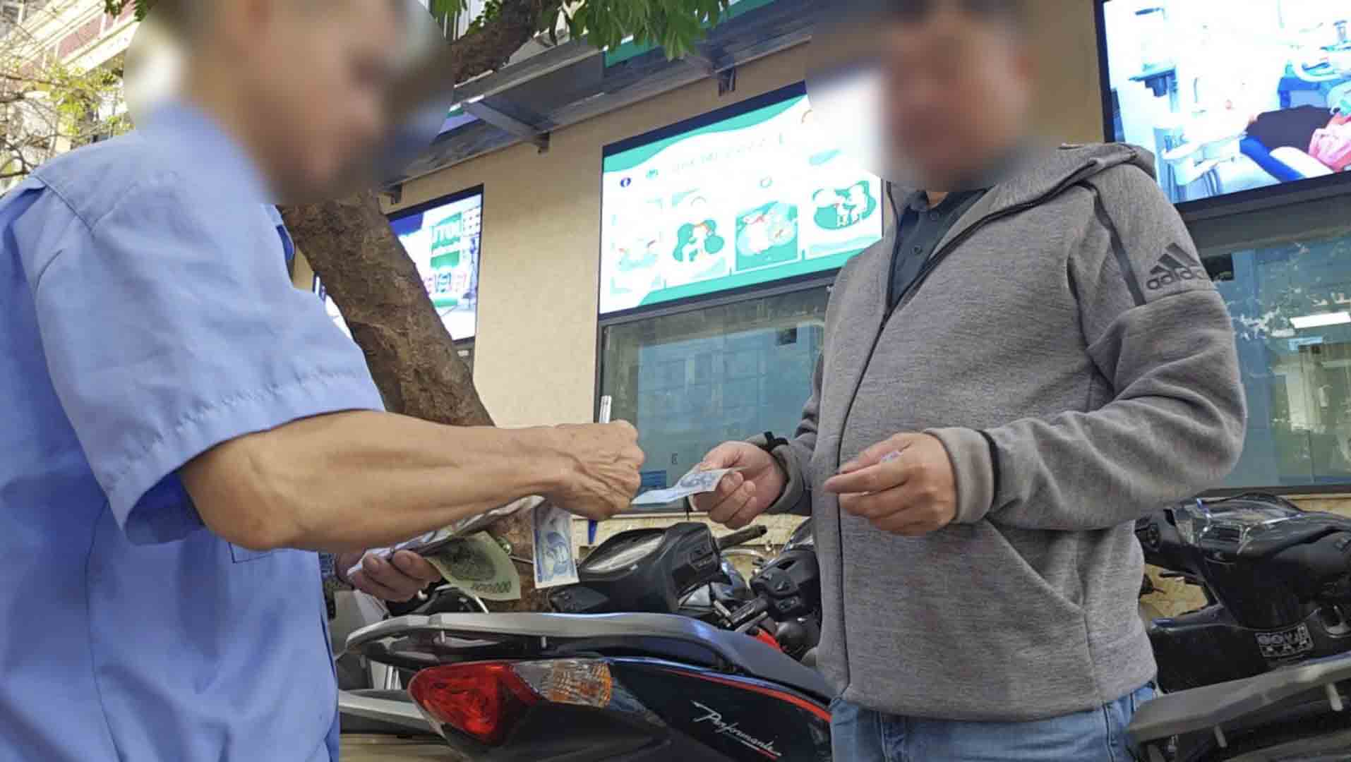 Collecting double the fee at a cashless parking lot in Hanoi. Photo: PV Group