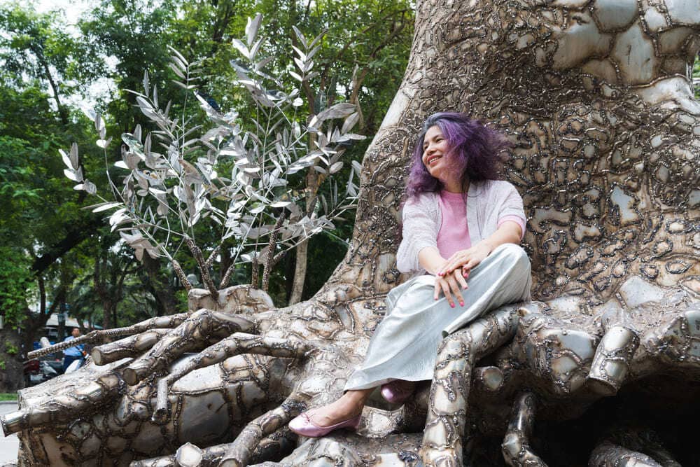 La artista Tia-Shui Nguyen junto a un arbol de jabones de 70 años de edad. Foto de la persona entrevistada