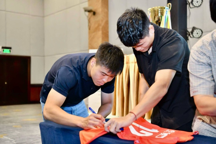 Cau thu Duy Manh va Tuan Hai ky tang ao cho cac cau thu nhi. Anh: Ban to chuc