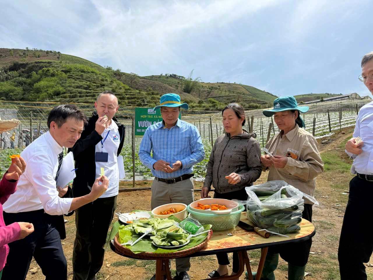 Truong Dai dien JICA Kobayashi Yosuke (thu hai tu trai) thuong thuc dua chuot va bi sach cua Hop tac xa Nong Xanh. Anh: Ngoc Van