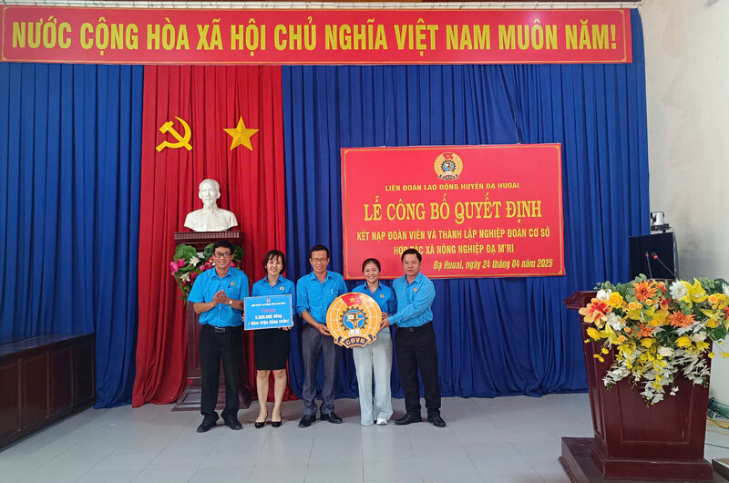 El Sr. Le Ngoc Phuc - Vicepresidente Permanente de la Federacion Laboral de Lam Dong (izquierda) otorgo a la insignia sindical de Vietnam y otorgo apoyo a la Union de base en el anuncio de la decision del establecimiento. Foto: Pham Yen